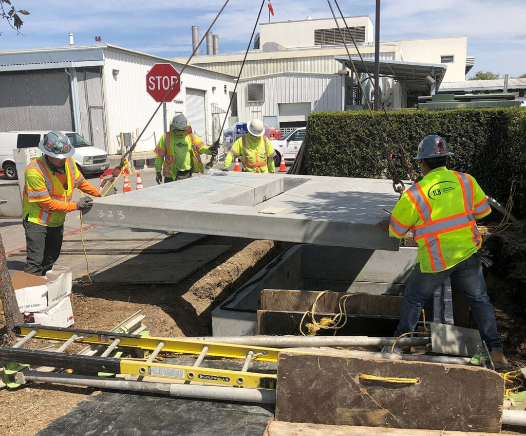 Employees setting concrete vault
